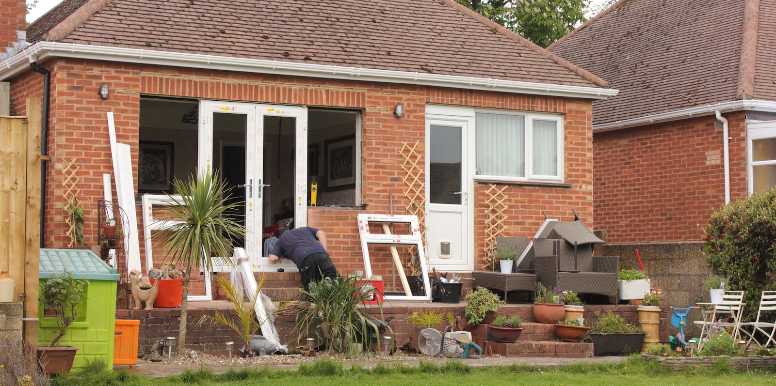 Replacing an old window with a door on a brick guest house