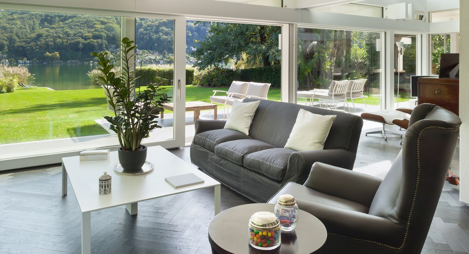 Modern patio doors opening onto a lawn and a lake