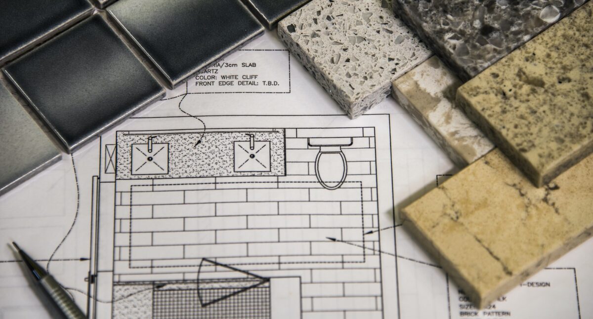 Blueprints and samples of tile flooring for a bathroom remodel